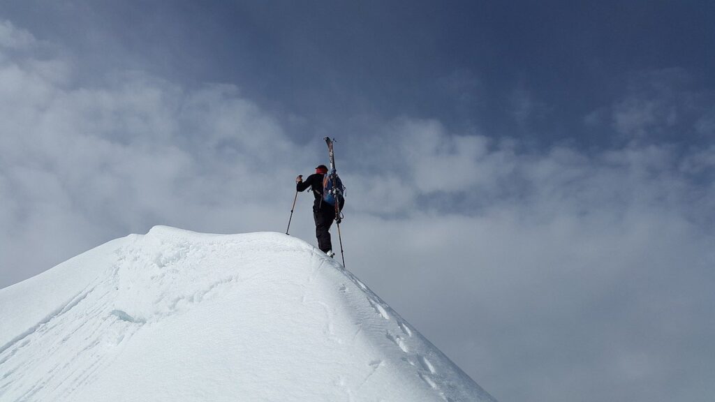 alpinista en una montaña blanca representa el esfuerzo sobre cómo escribir un libro por primera vez